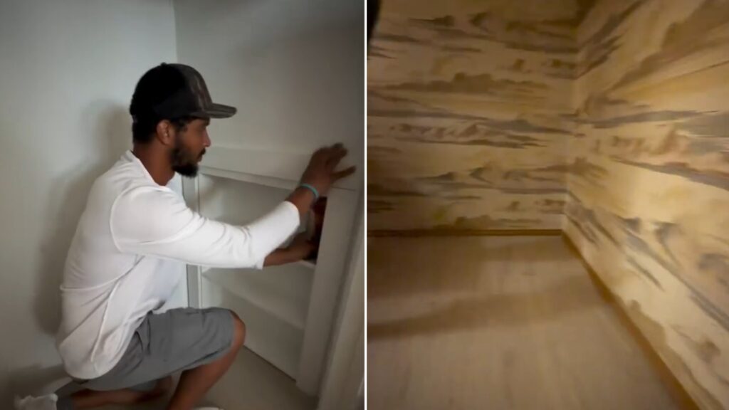 Contractor removing a closet shelving unit, beside the wood-paneled hidden space found behind it