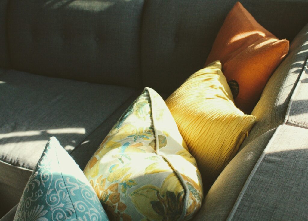 white and blue floral throw pillow on black sofa