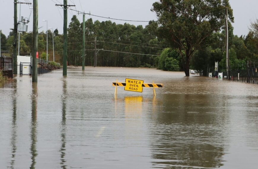 a flooded street with a yellow sign