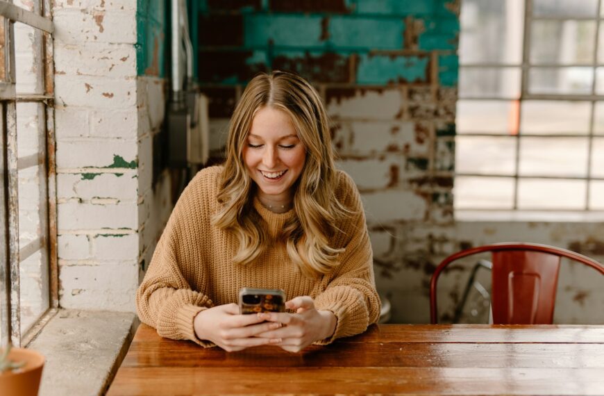 a woman sitting at a table looking at her cell phone