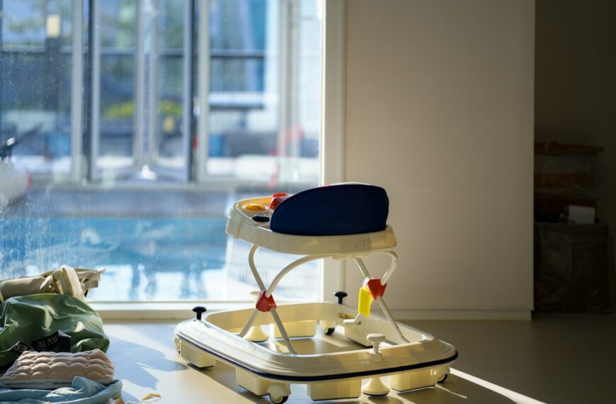 A baby walker sits by a sunlit window