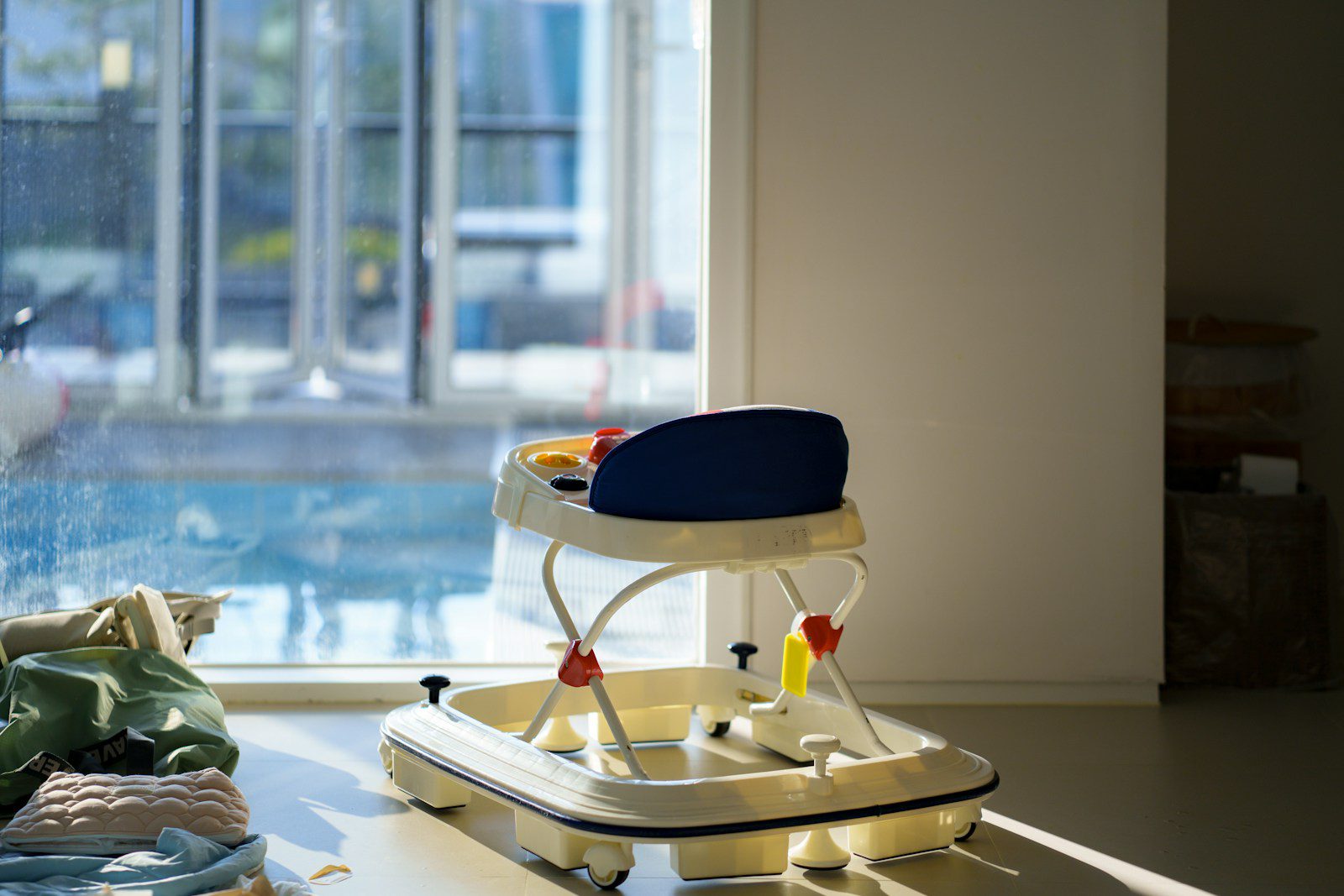 A baby walker sits by a sunlit window