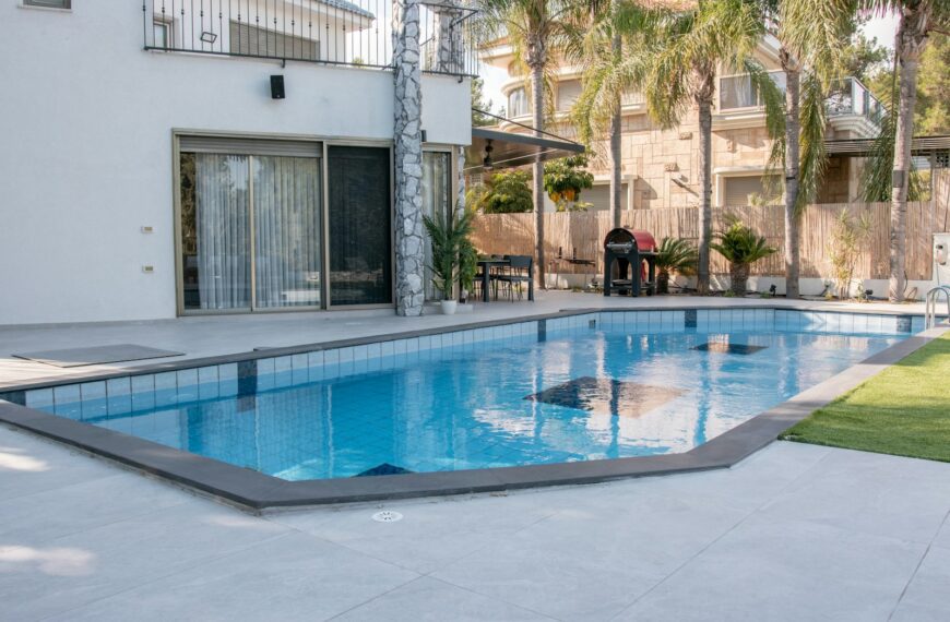 A modern house with a swimming pool and palm trees