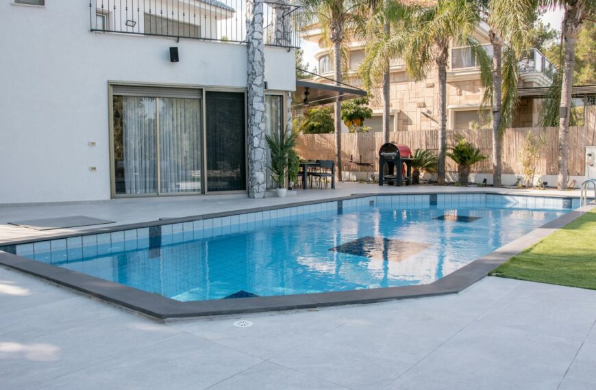 A modern house with a swimming pool and palm trees