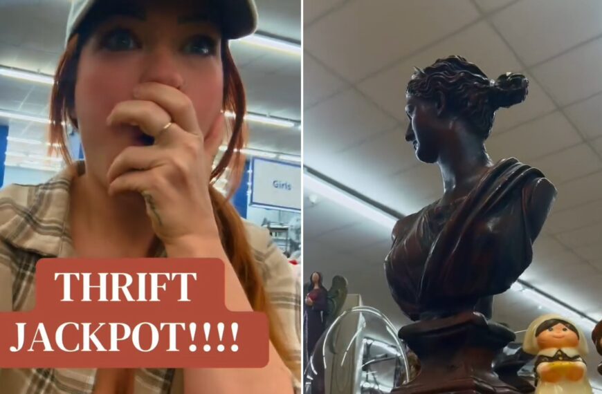 Thrifter reacting to her find, beside the carved wooden bust on a Goodwill shelf