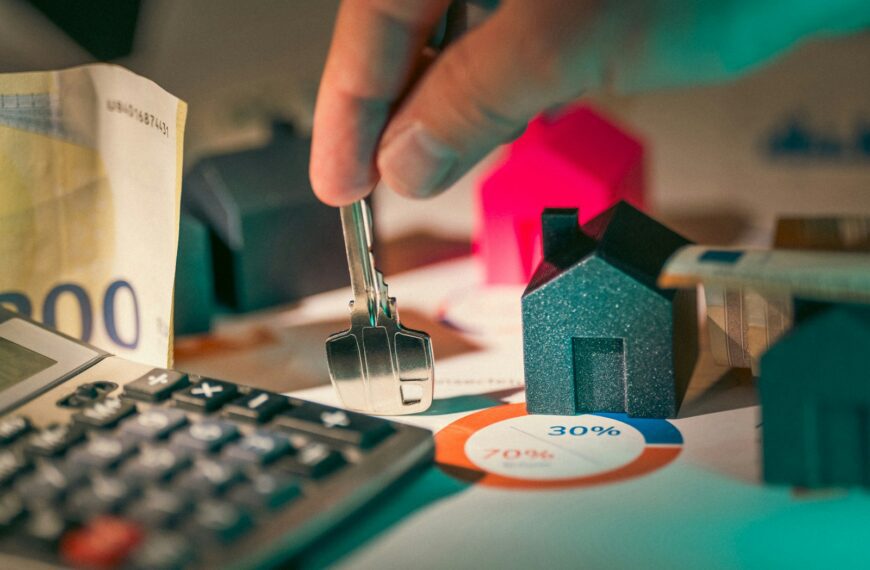 hand holding key over house models