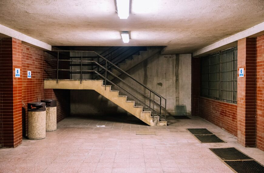 brown concrete staircase with stainless steel railings