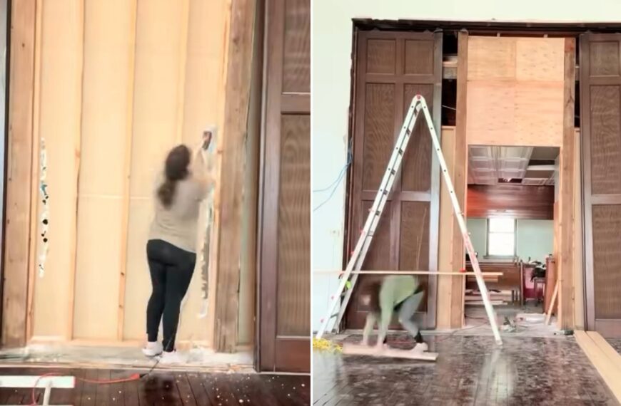 Owner tearing into drywall beside the uncovered fifteen-foot wooden pocket doors