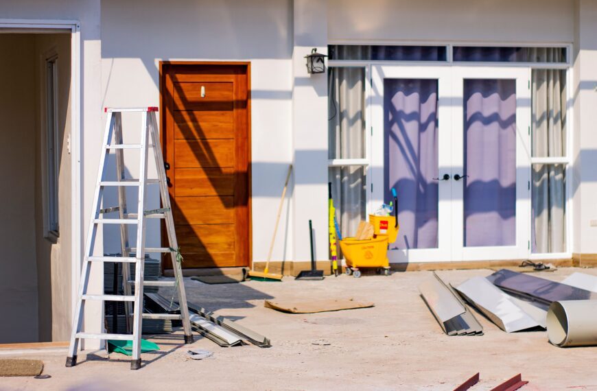 Front entrance of a house under renovation with tools and materials scattered around