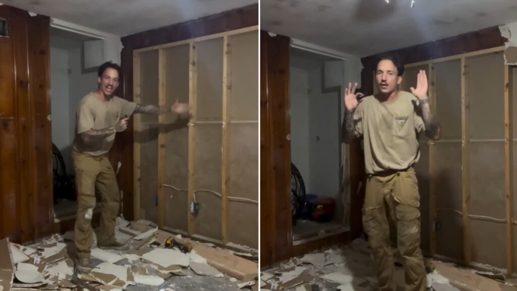 Homeowner standing in his gutted room with stripped walls and drywall debris during his renovation