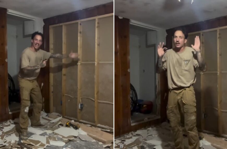 Homeowner standing in his gutted room with stripped walls and drywall debris during his renovation