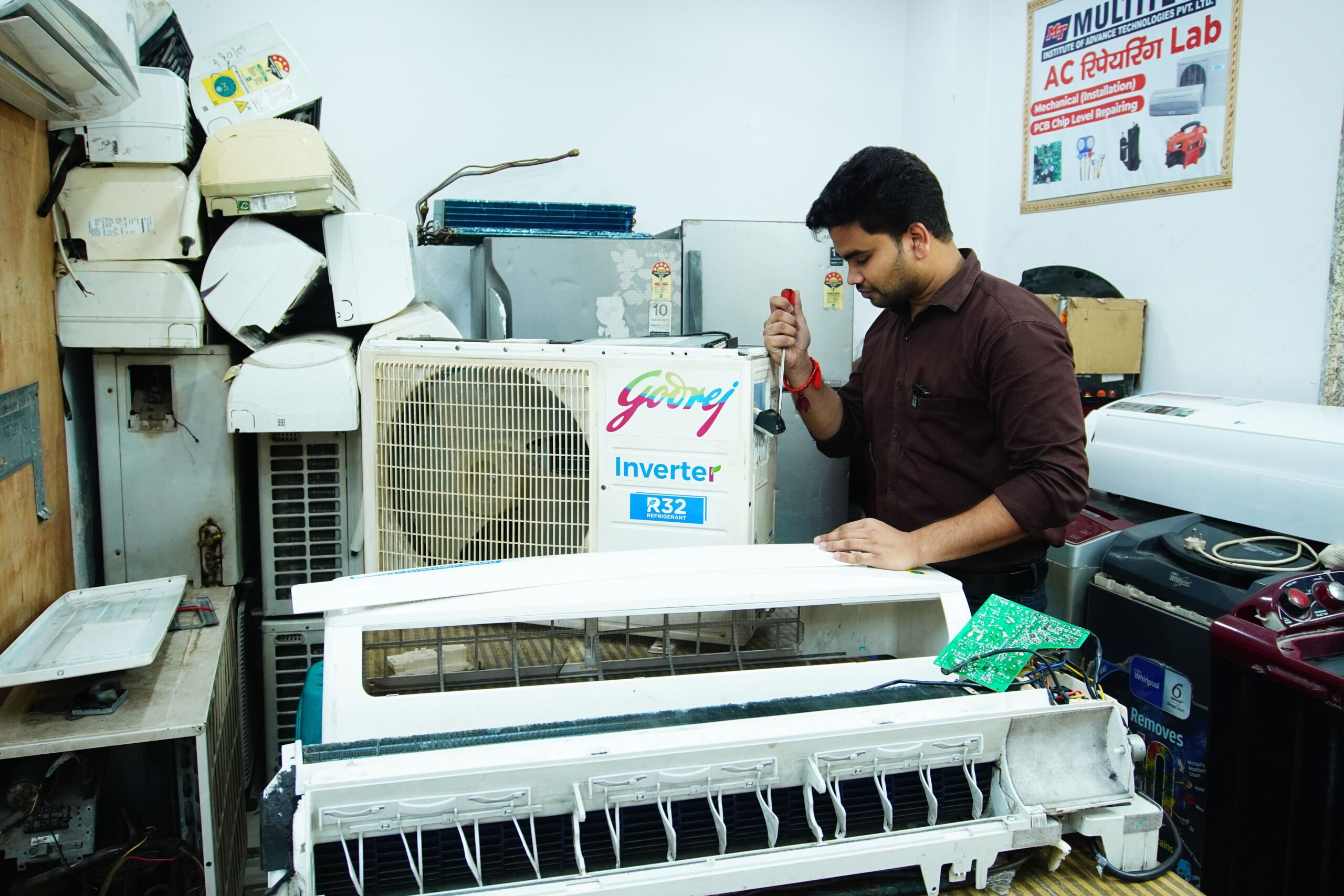 A technician repairing an air conditioning unit in a workshop