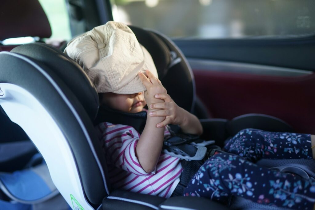 A child has a bag over their head in car