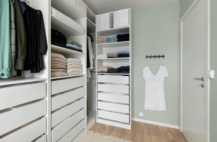 A walk in closet filled with lots of white drawers