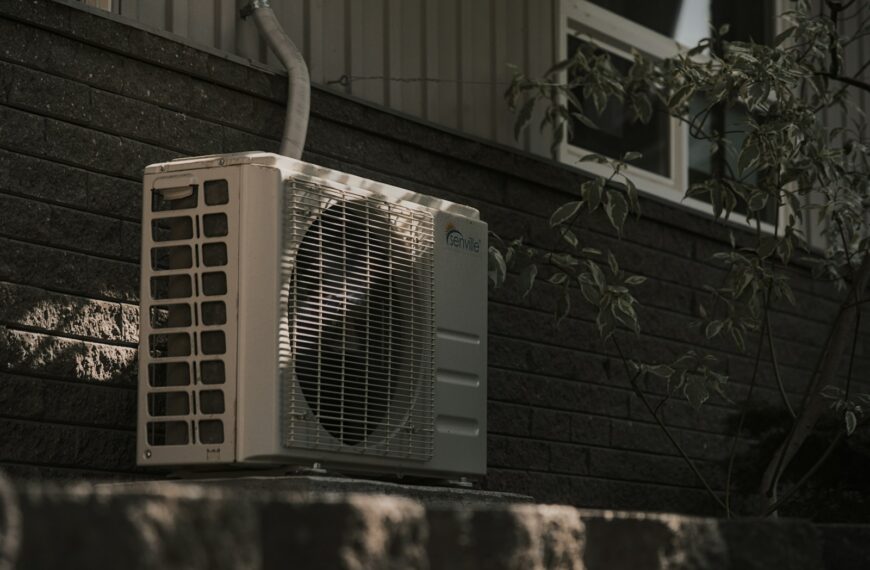 a white air conditioner sitting on top of a brick wall
