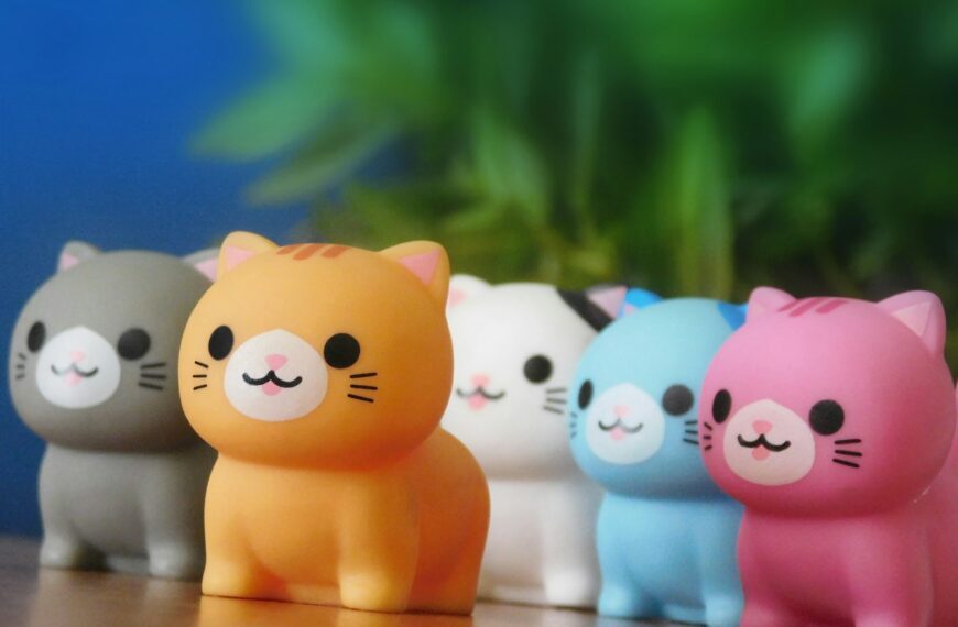 Five colorful cat figurines in a row