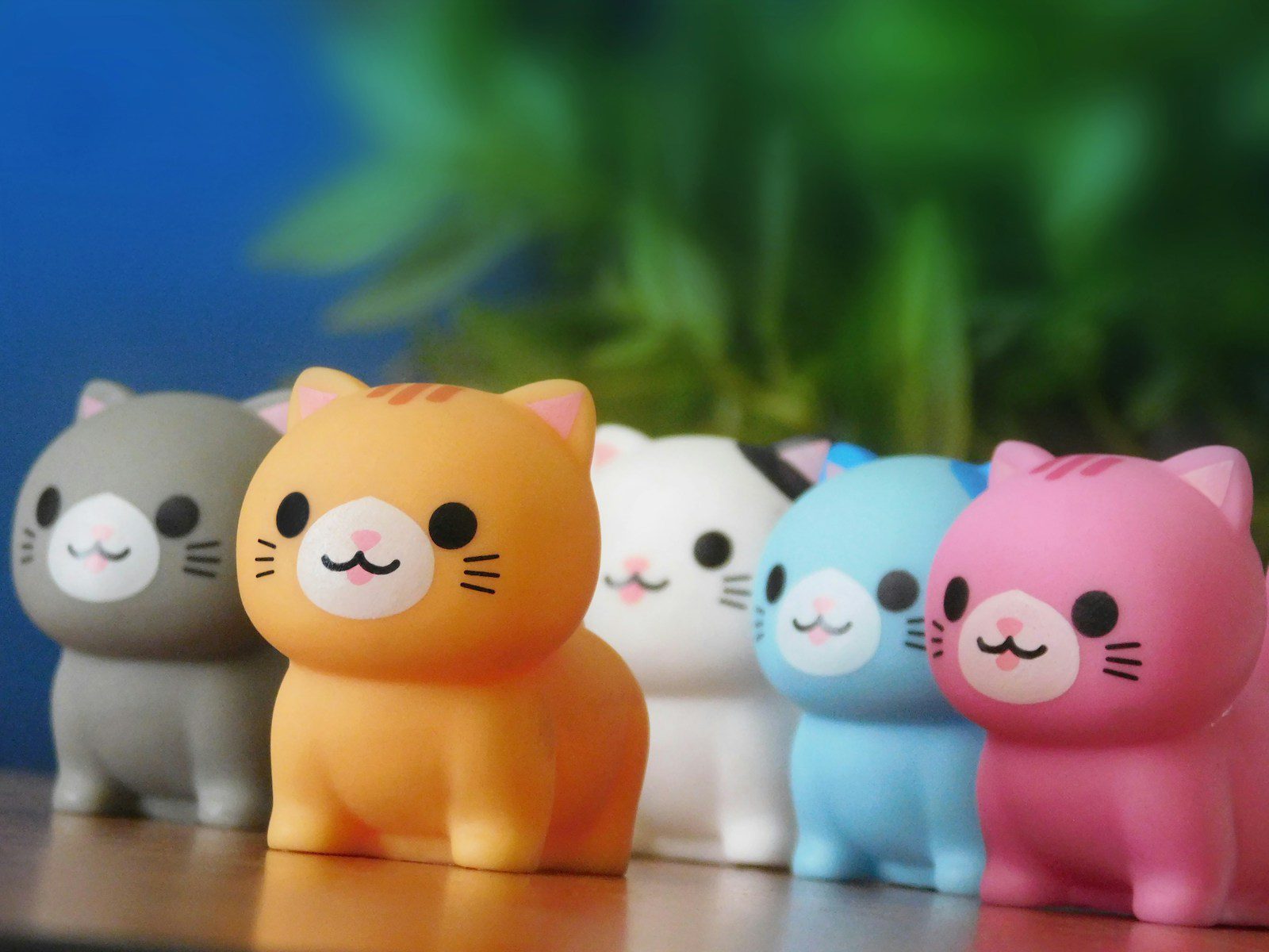 Five colorful cat figurines in a row