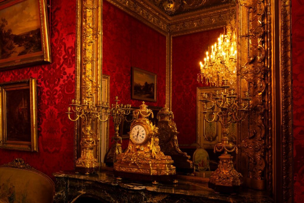 Ornate golden clock on a marble fireplace mantel