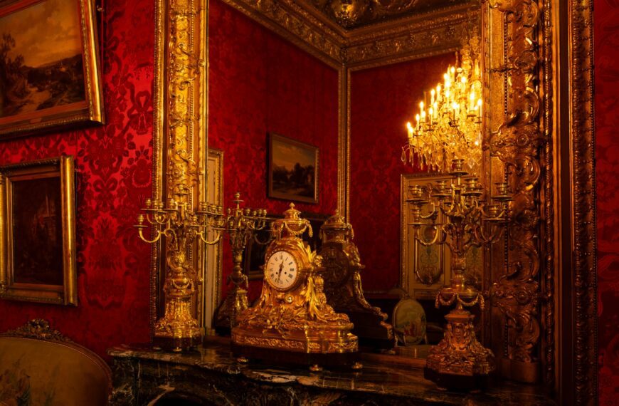 Ornate golden clock on a marble fireplace mantel