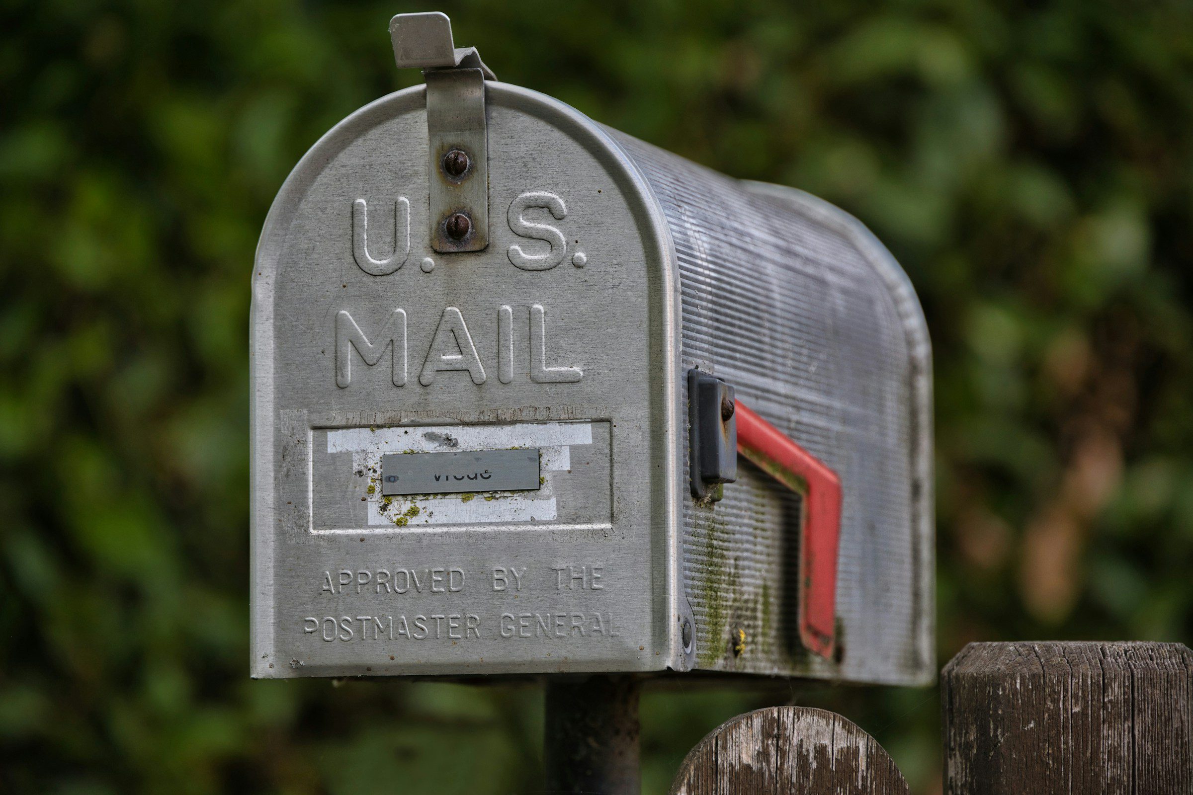 Weathered US mailbox with red flag raised, representing property tax reassessment notices arriving by mail