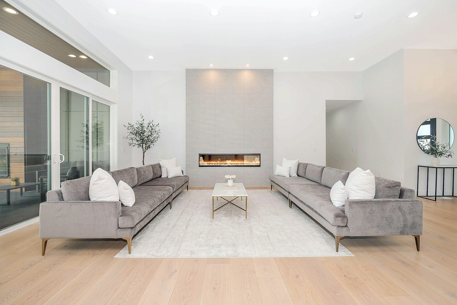 Two grey velvet sofas facing each other in a bright modern living room
