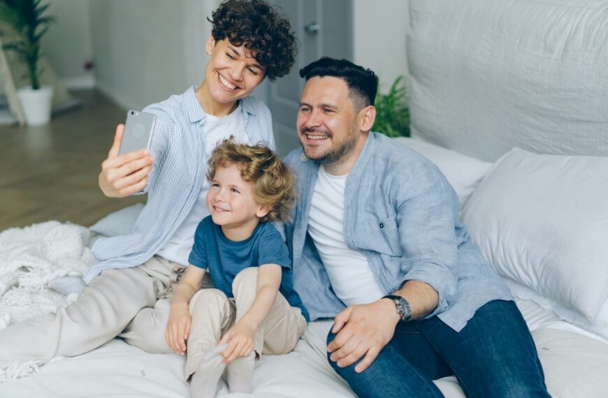 a man and two children sitting on a bed