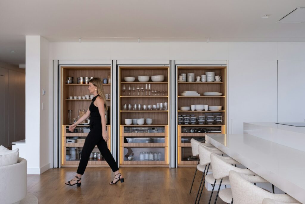 Woman walking past modern built-in shelving