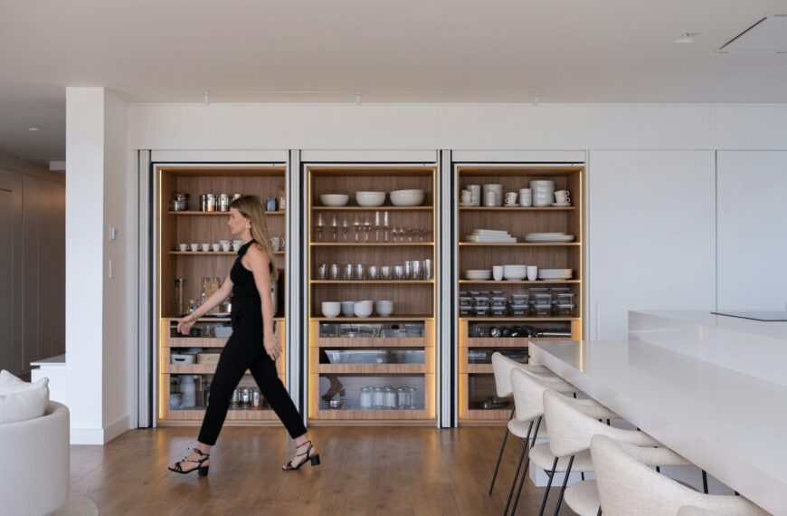 Woman walking past modern built-in shelving