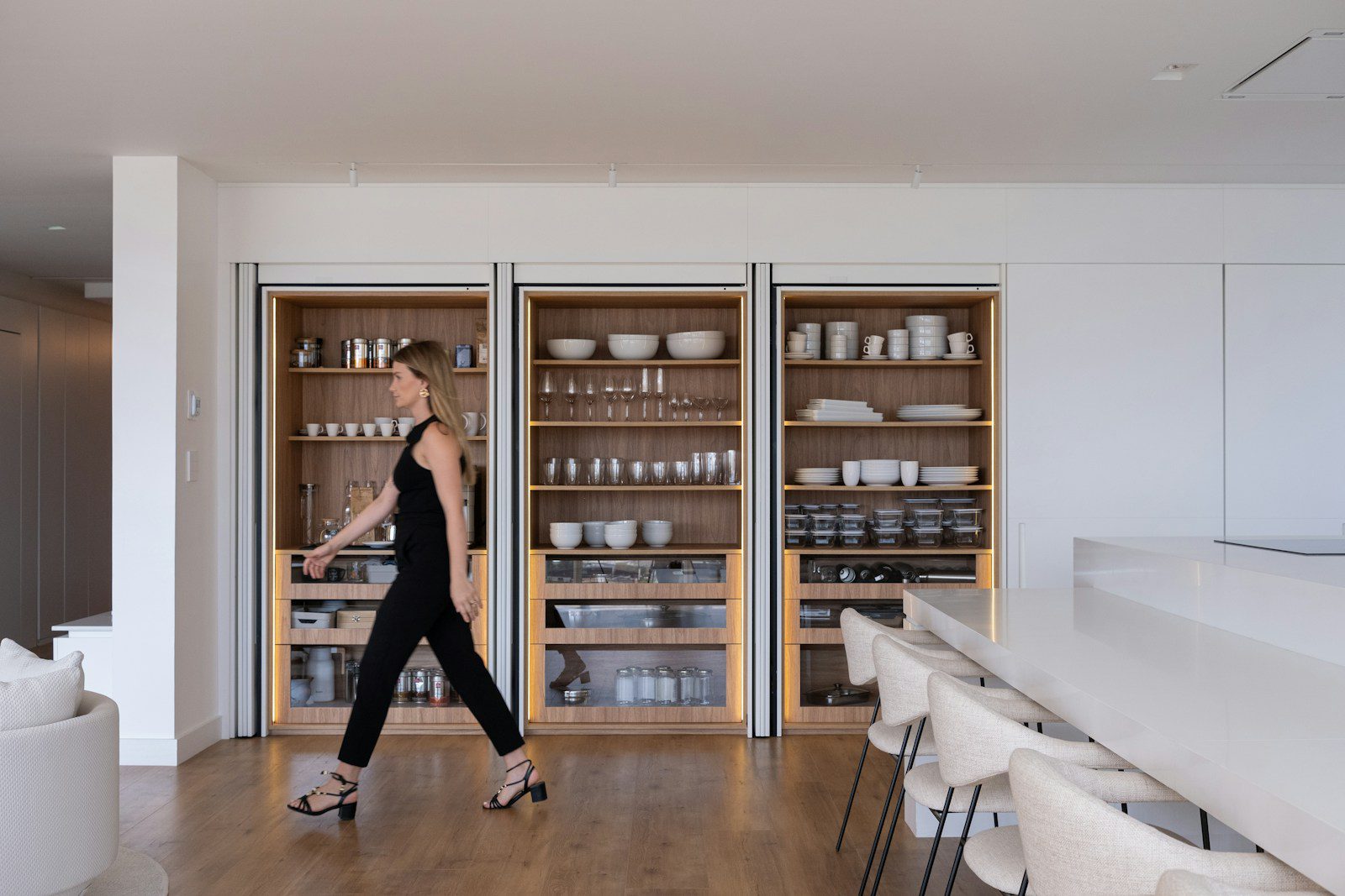 Woman walking past modern built-in shelving
