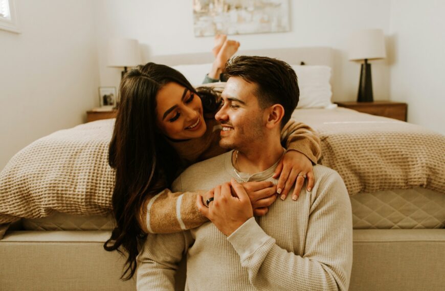 a man and a woman sitting on a bed together