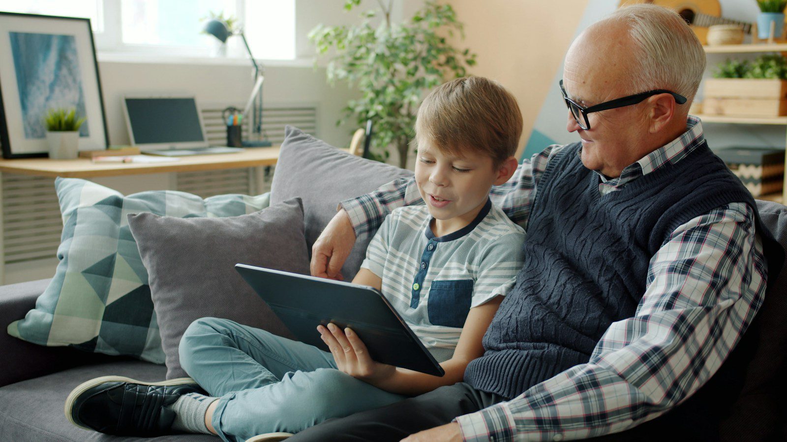 Grandfather and grandson looking at a tablet together