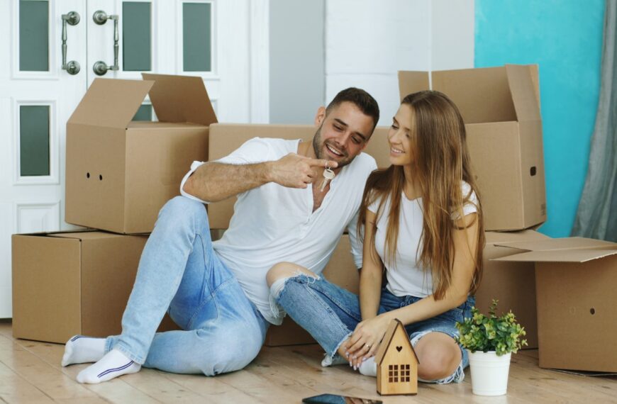 Couple sitting among moving boxes in new home