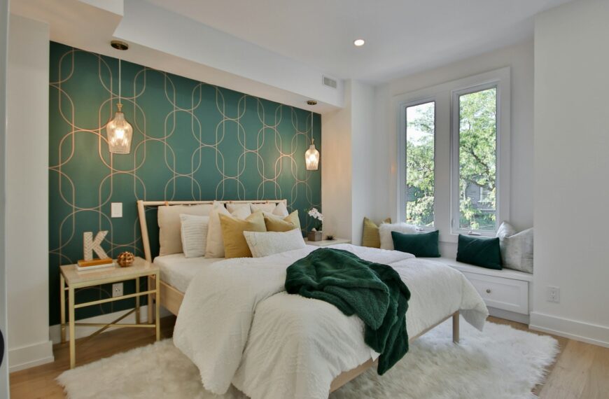 a bedroom with a green wall and a white bed