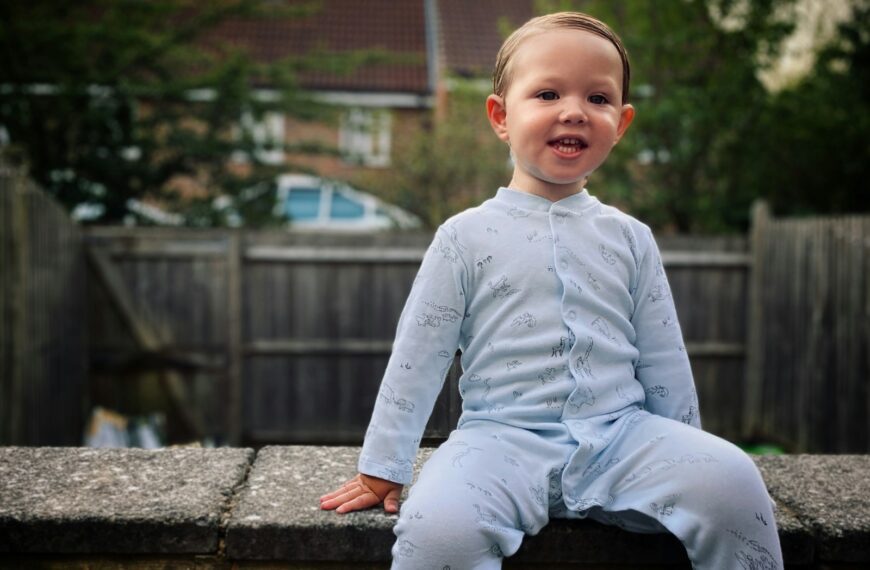 a little boy that is sitting on a wall