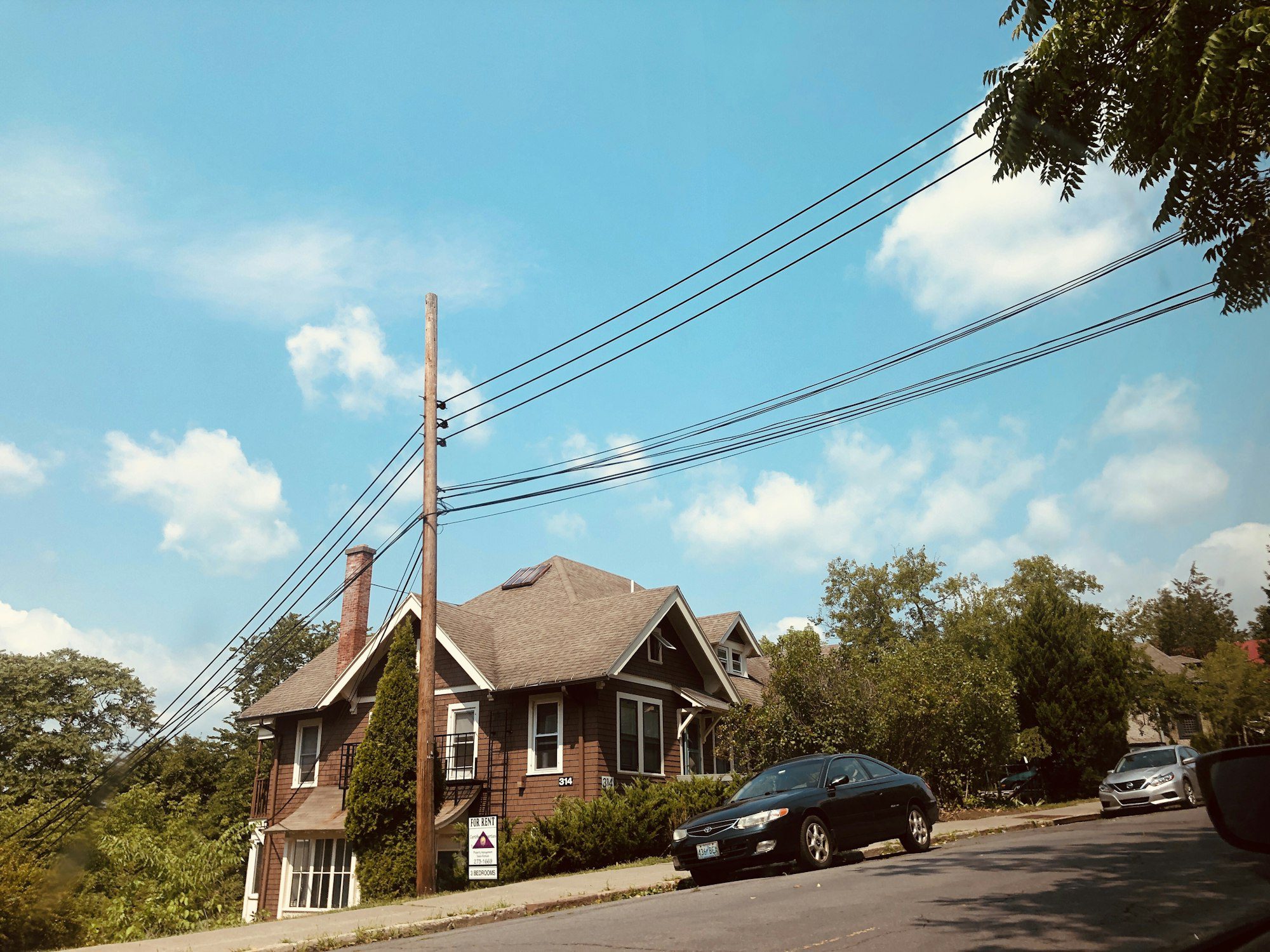 Small suburban starter home with a car parked in the driveway