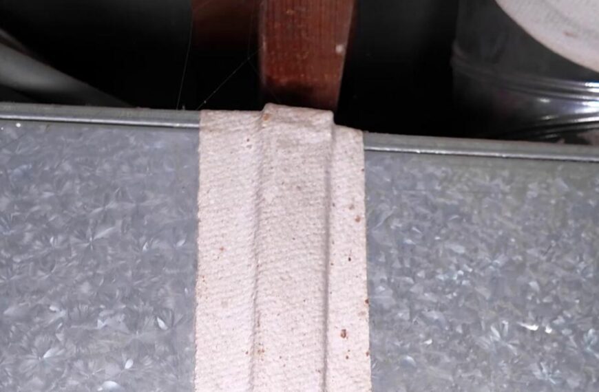 Close-up of white fibrous tape sealing a galvanized HVAC duct seam under a wooden joist, from the sprucehill.homes TikTok