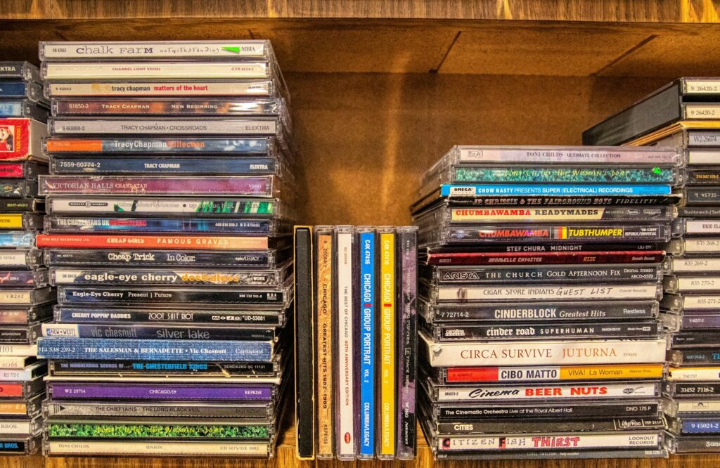 assorted cd case on brown wooden shelf