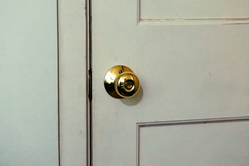 A close up of a door handle on a white door
