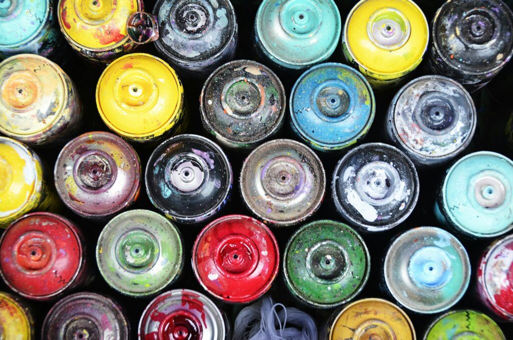 A collection of colorful, used spray paint cans