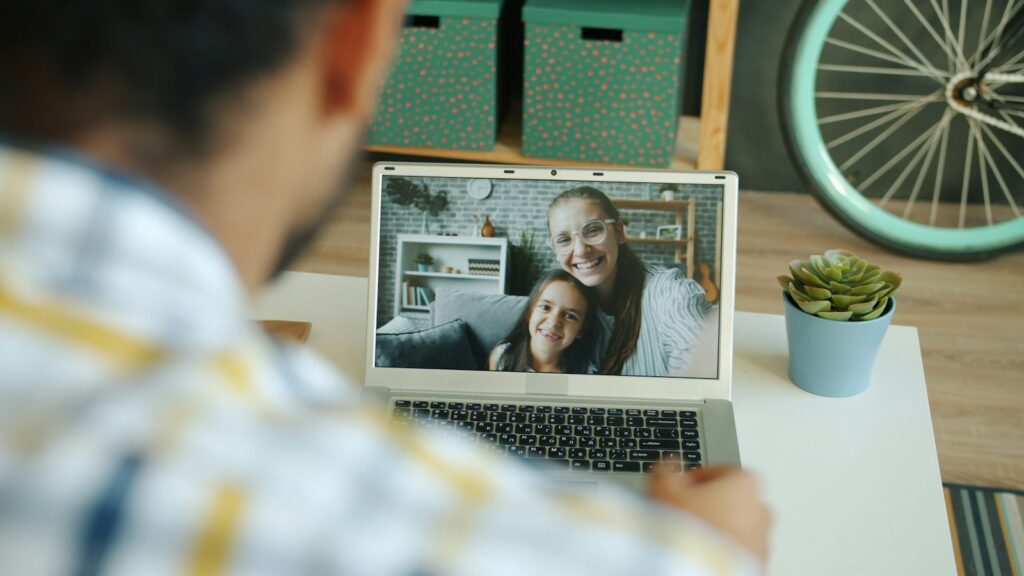 Man video calls with a woman and child