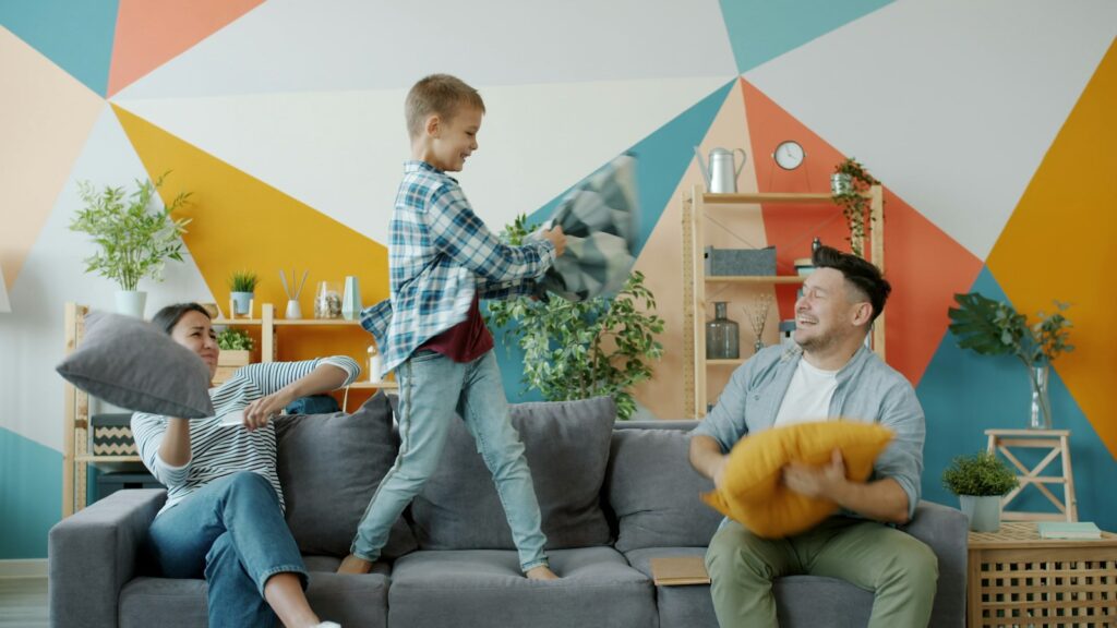 Family having a pillow fight on the couch