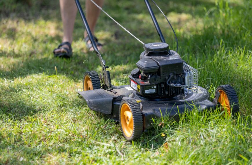 a person mowing the grass with a lawn mower