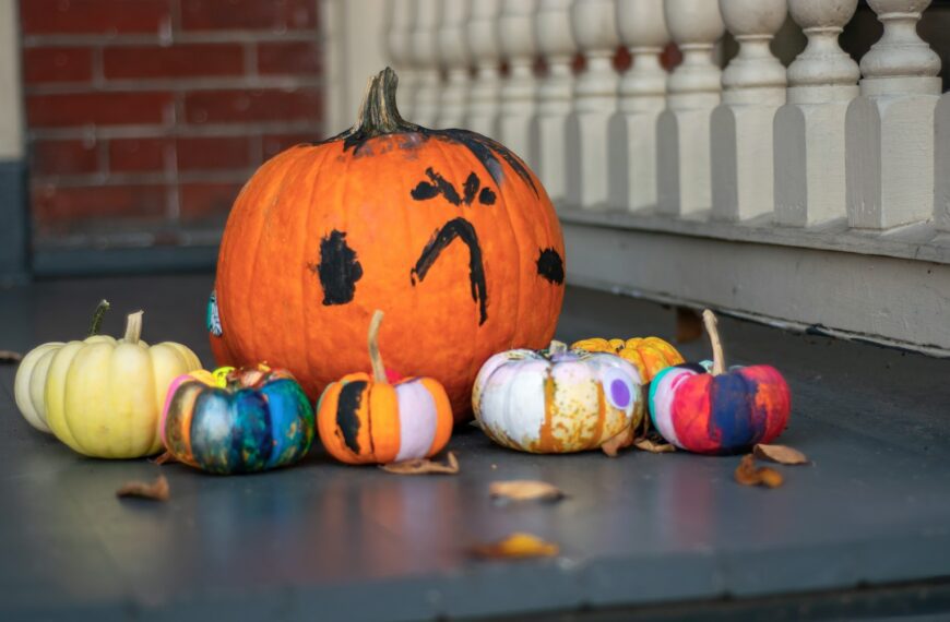 a group of painted pumpkins sitting on a porch