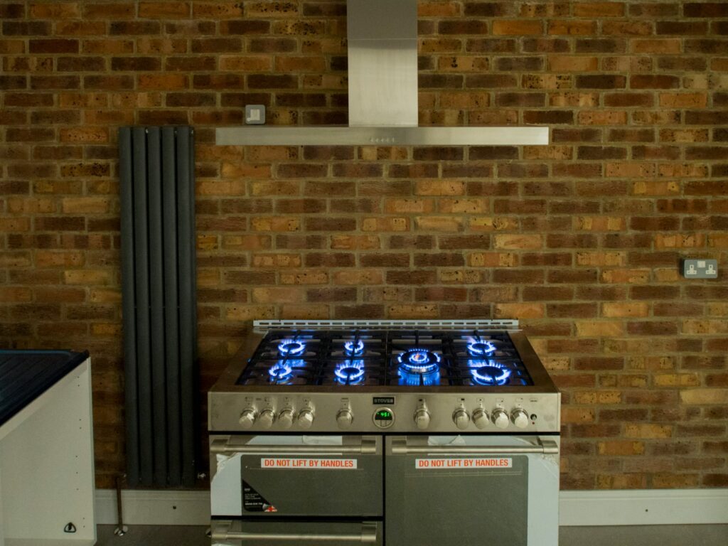 A stove top oven sitting in front of a brick wall