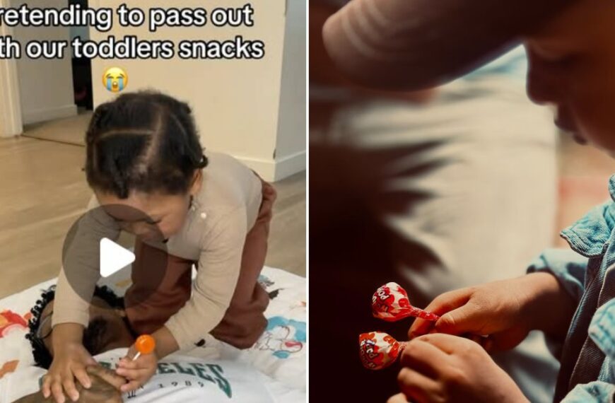 Father holding a toddler with a lollipop