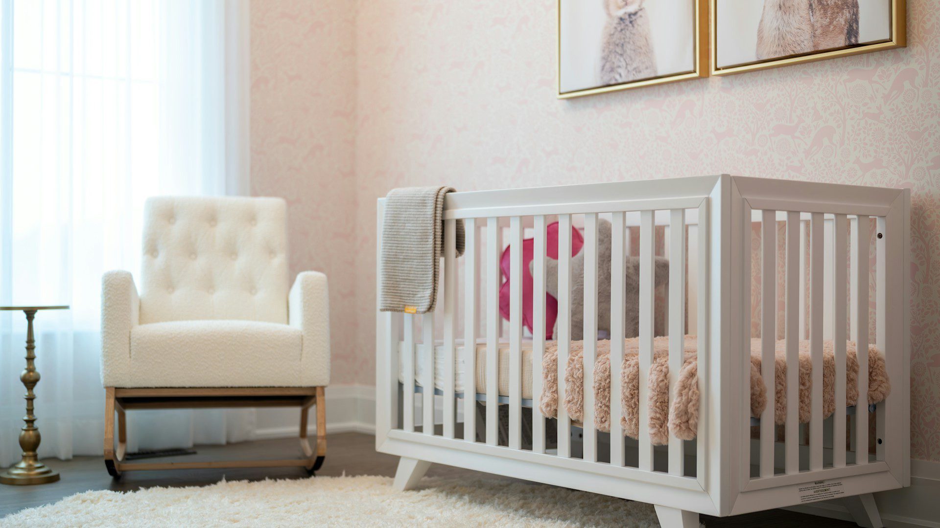 A cozy nursery with a white crib and a tufted armchair.