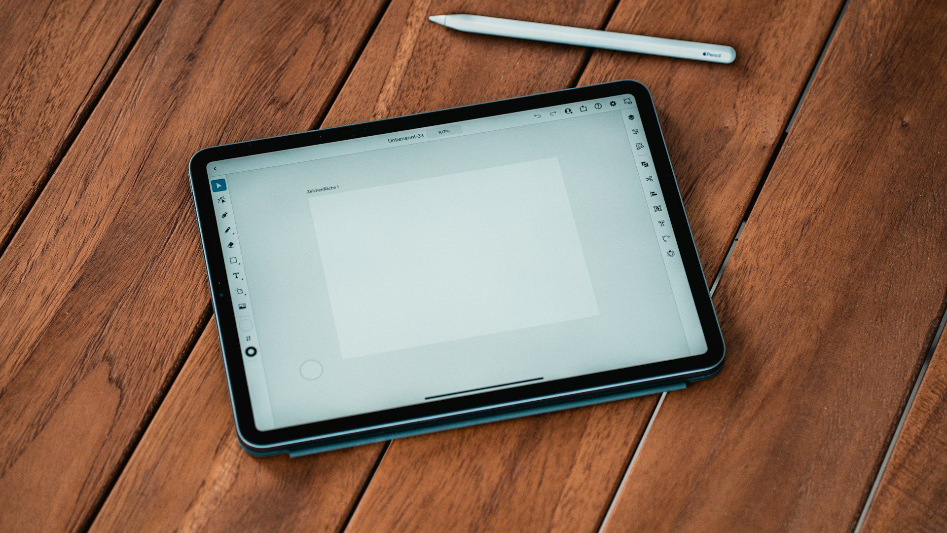 A tablet and stylus resting on a wooden table.