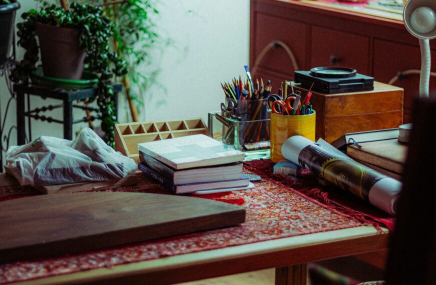 Art supplies and books neatly arranged on a wooden desk.