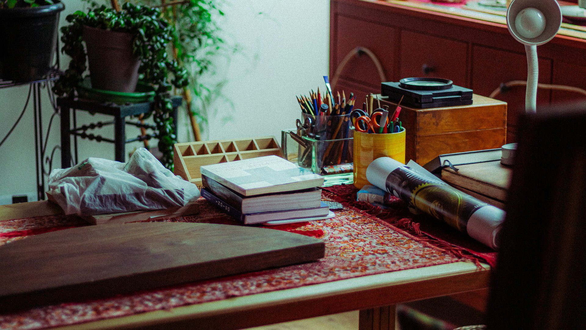 Art supplies and books neatly arranged on a wooden desk.