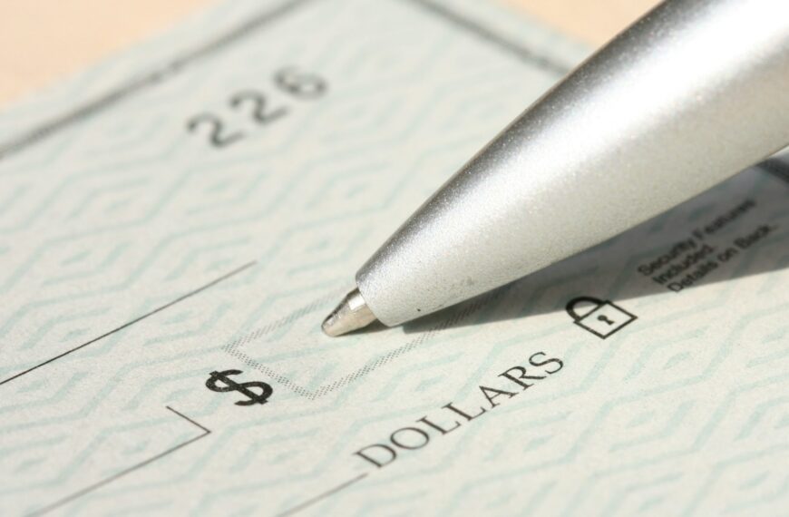 A pen resting on a blank check.